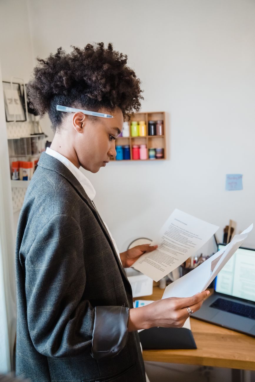 A business owner reviewing paperwork at her desk with the day's jobs in front of her